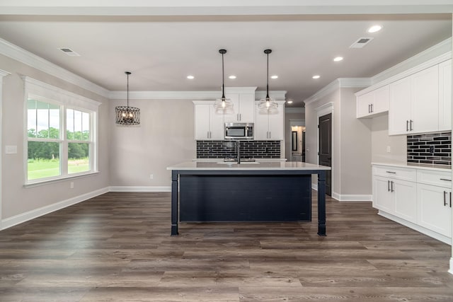2421 Laurens St, Grovetown, GA 30813 - kitchen featuring stainless steel microwave, ornamental molding, baseboards, light countertops, and backsplash