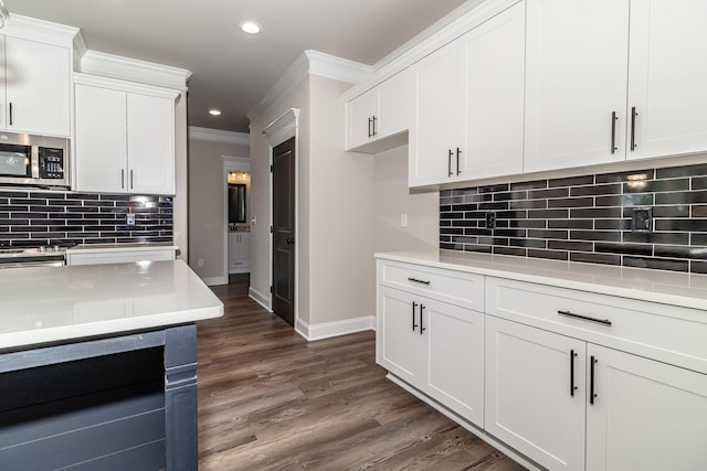 2421 Laurens St, Grovetown, GA 30813 - kitchen with stainless steel microwave, baseboards, light countertops, crown molding, and tasteful backsplash