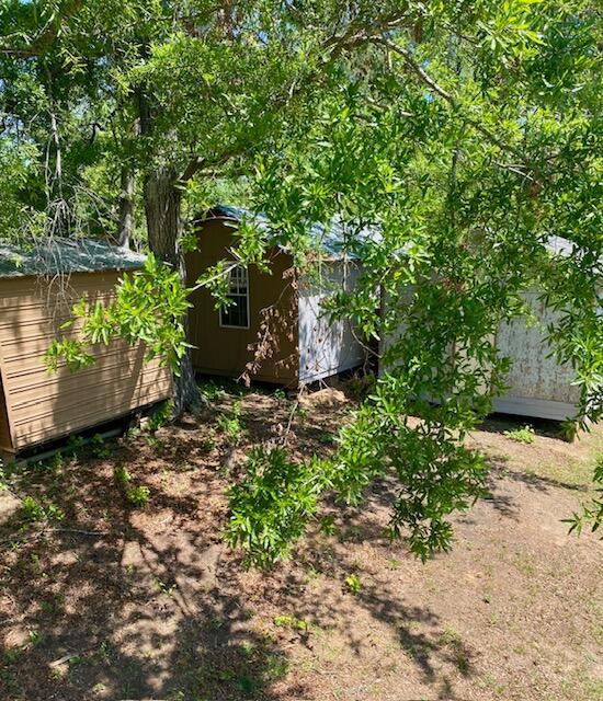 view of yard featuring a storage unit and an outbuilding