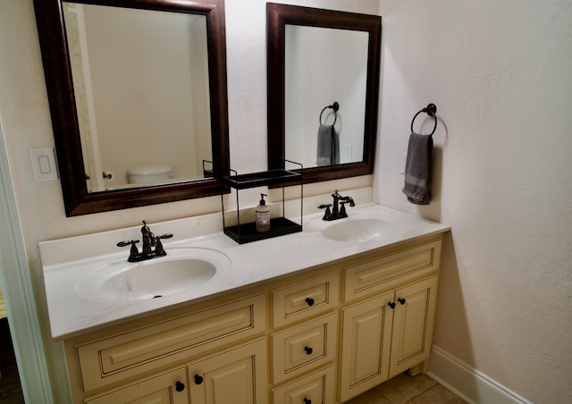 bathroom featuring tile patterned flooring, vanity, and toilet