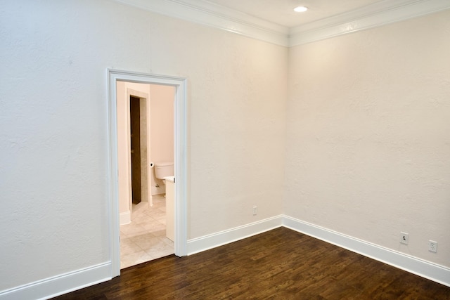 empty room featuring wood-type flooring and crown molding