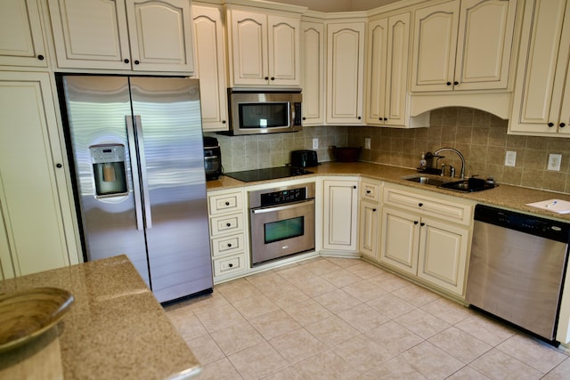 kitchen with decorative backsplash, sink, light tile patterned floors, and appliances with stainless steel finishes