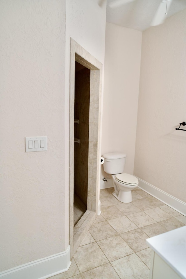 bathroom featuring tile patterned floors, toilet, and tiled shower