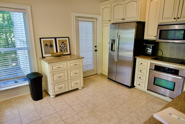 kitchen with decorative backsplash, light tile patterned flooring, and appliances with stainless steel finishes