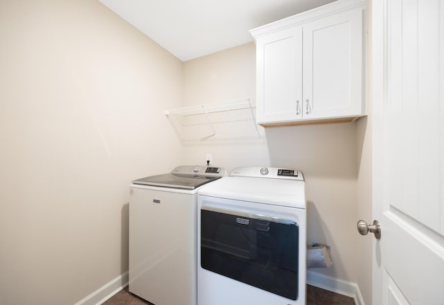 clothes washing area featuring cabinets and washer and clothes dryer