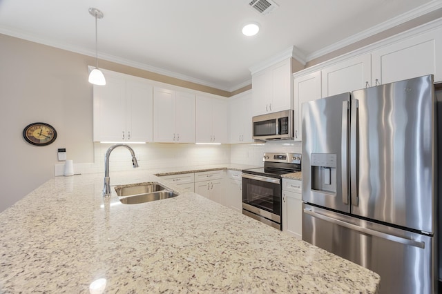 kitchen with hanging light fixtures, white cabinetry, appliances with stainless steel finishes, and sink