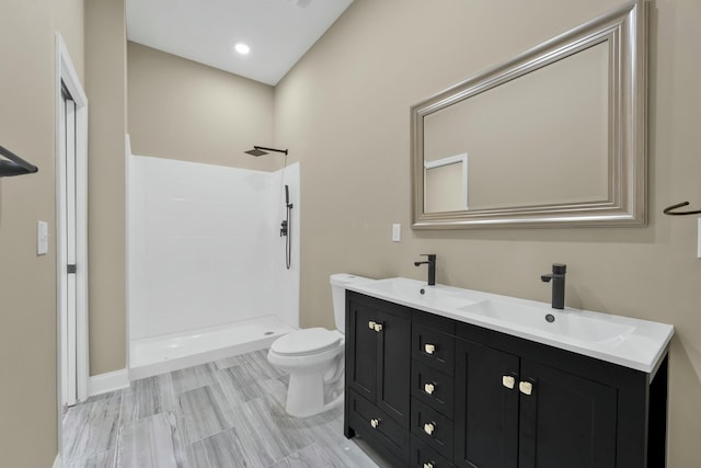 bathroom featuring toilet, vanity, and walk in shower