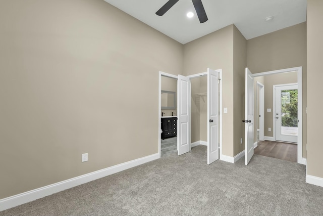 unfurnished bedroom featuring light carpet, a closet, and ceiling fan