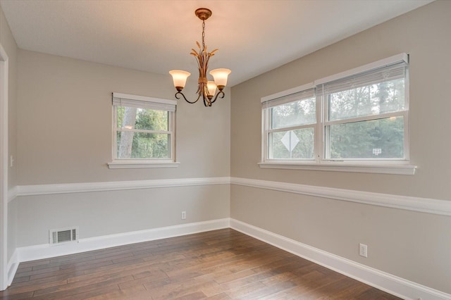 unfurnished room featuring a chandelier and hardwood / wood-style flooring