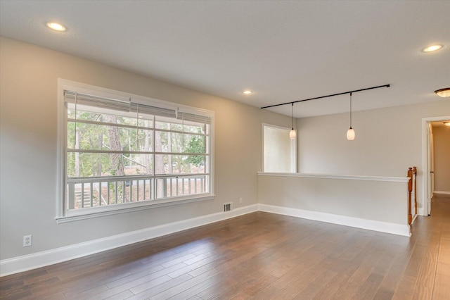 unfurnished room featuring dark hardwood / wood-style flooring and plenty of natural light