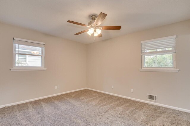 spare room with carpet floors, plenty of natural light, and ceiling fan