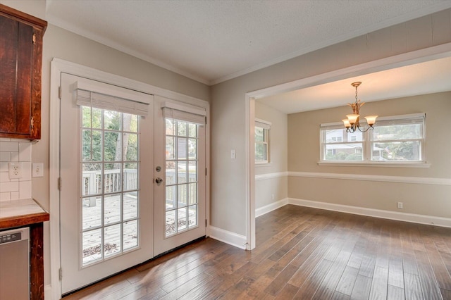 entryway featuring dark hardwood / wood-style flooring, a healthy amount of sunlight, french doors, and a chandelier