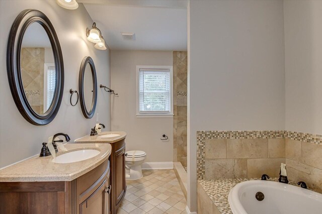 bathroom with tile patterned flooring, a washtub, vanity, and toilet