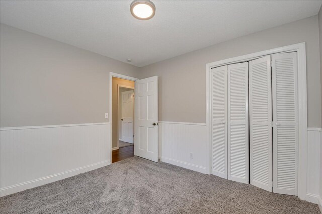 unfurnished bedroom featuring carpet floors and a closet