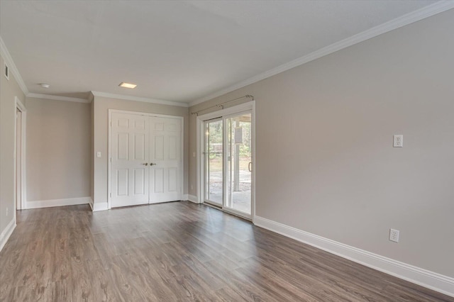 empty room featuring ornamental molding and dark wood-type flooring