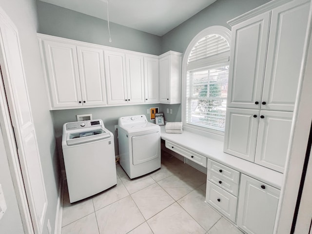 laundry room with cabinet space, light tile patterned flooring, and independent washer and dryer