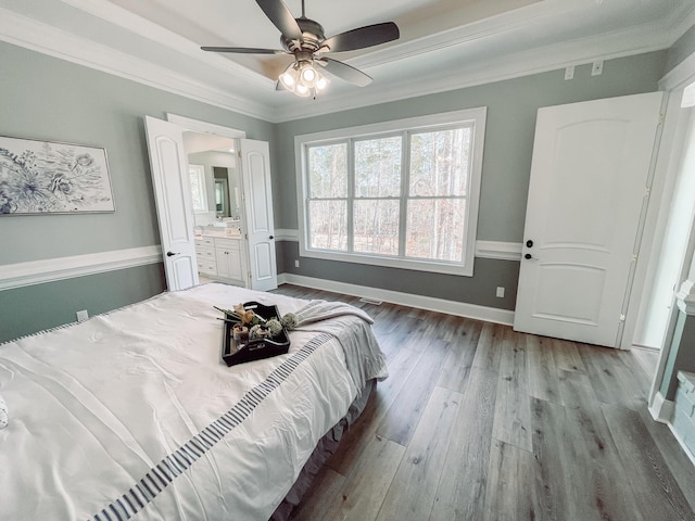 bedroom featuring light wood-style floors, connected bathroom, ornamental molding, and baseboards