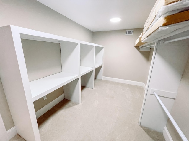 spacious closet featuring visible vents and light colored carpet