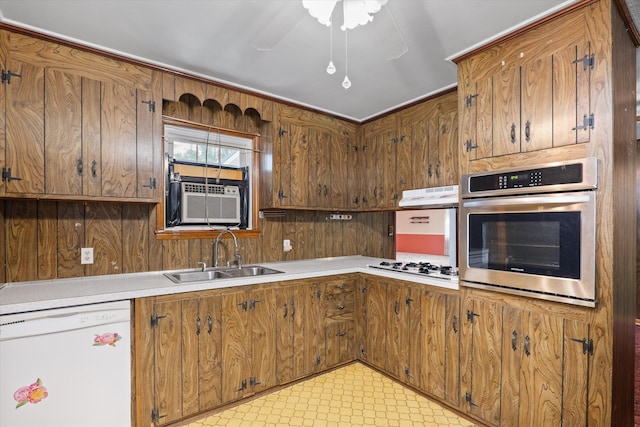 kitchen featuring cooling unit, white appliances, sink, and wooden walls