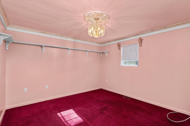 carpeted spare room with an inviting chandelier and ornamental molding