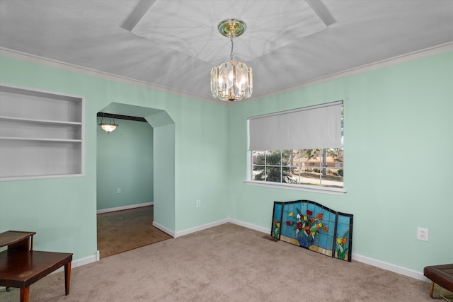 interior space with built in features, crown molding, and a notable chandelier