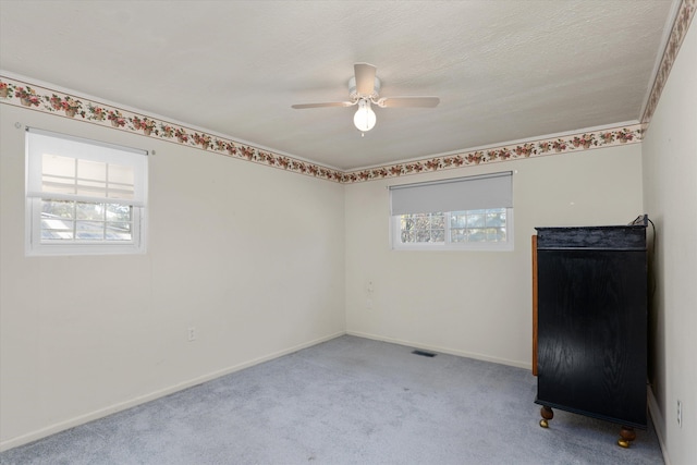 empty room featuring ceiling fan and light carpet