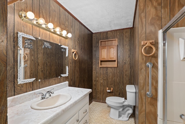 bathroom with vanity, wooden walls, toilet, ornamental molding, and a textured ceiling