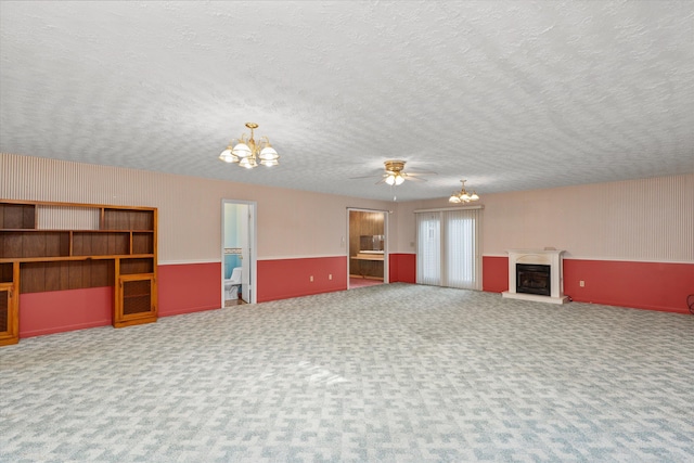 carpeted living room featuring a textured ceiling and ceiling fan with notable chandelier