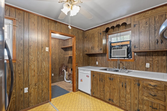 kitchen with dishwasher, sink, and wooden walls