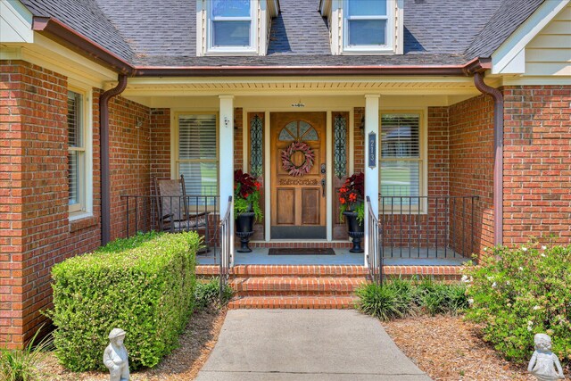 213 Oak Ln, Waynesboro, GA 30830 - doorway to property featuring covered porch, brick siding, and a shingled roof