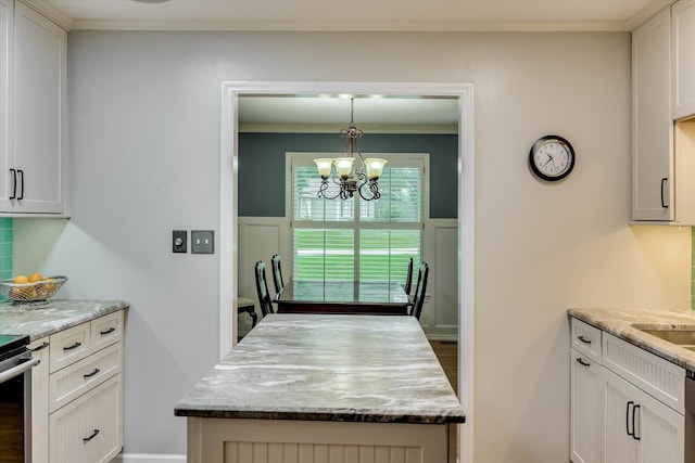 213 Oak Ln, Waynesboro, GA 30830 - kitchen featuring a chandelier, crown molding, white cabinetry, light stone counters, and a kitchen island