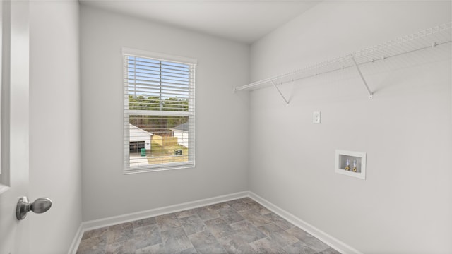 clothes washing area featuring stone finish flooring, baseboards, washer hookup, and laundry area