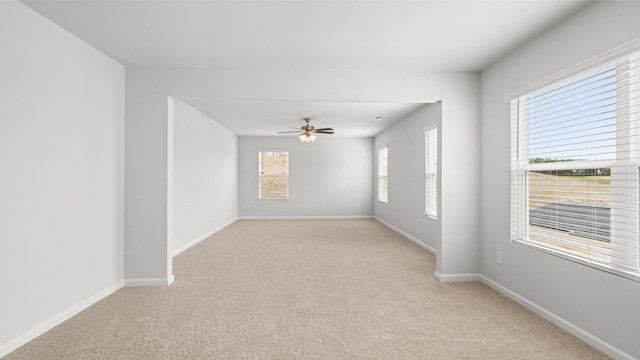 unfurnished room with baseboards, light colored carpet, and ceiling fan