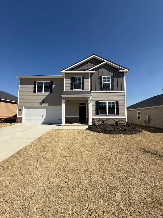 view of front of house featuring stone siding, board and batten siding, concrete driveway, and a garage