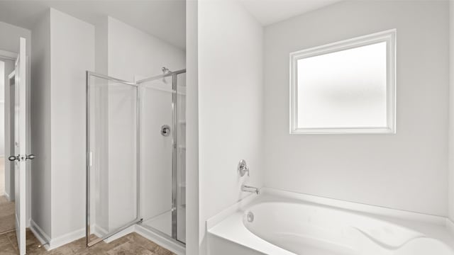 full bath featuring a garden tub and a stall shower