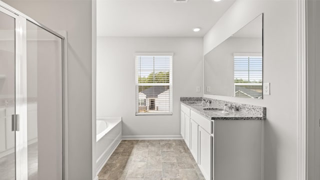 bathroom featuring plenty of natural light, a bath, and a sink