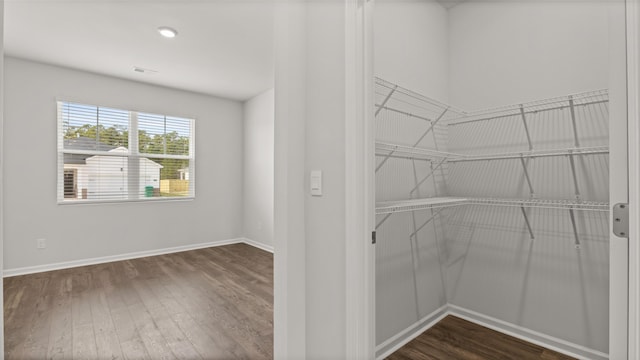 spacious closet featuring dark wood-style floors and visible vents