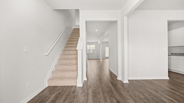 staircase with wood finished floors and baseboards