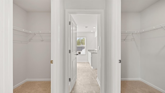 walk in closet featuring light carpet