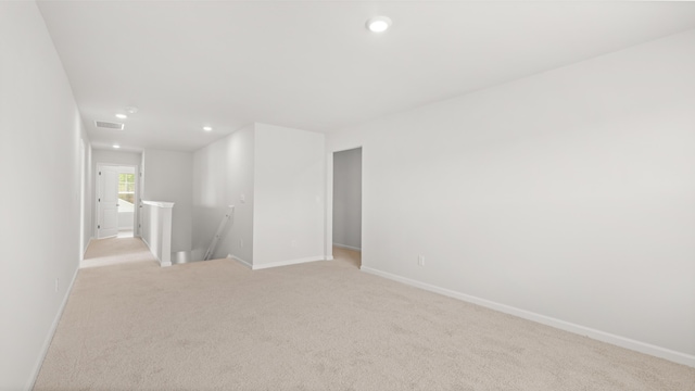 empty room with light carpet, visible vents, recessed lighting, and baseboards