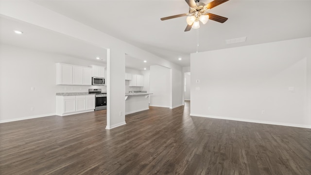 unfurnished living room featuring dark wood finished floors, baseboards, and a ceiling fan