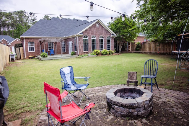 4725 Park Ridge Ct, Evans, GA 30809 - view of yard featuring a trampoline, an outdoor fire pit, a wooden deck, a fenced backyard, and a patio