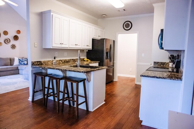 4725 Park Ridge Ct, Evans, GA 30809 - kitchen featuring black microwave, dark stone countertops, ornamental molding, a breakfast bar, and white cabinetry