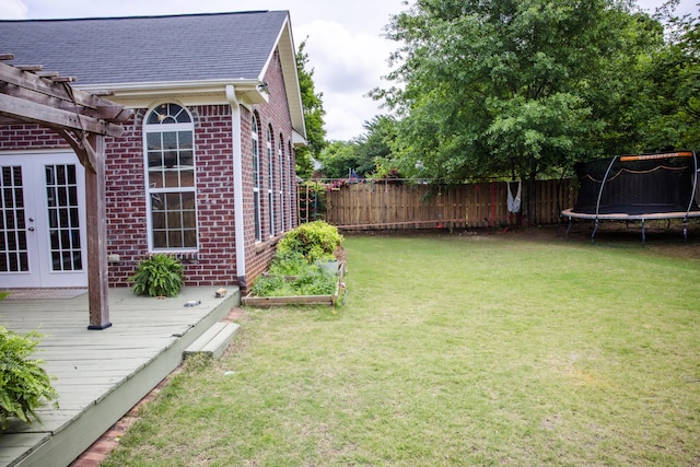 4725 Park Ridge Ct, Evans, GA 30809 - view of yard with french doors, a trampoline, a wooden deck, a fenced backyard, and a pergola