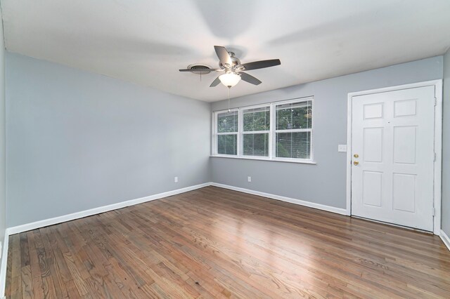 empty room with ceiling fan and dark hardwood / wood-style floors