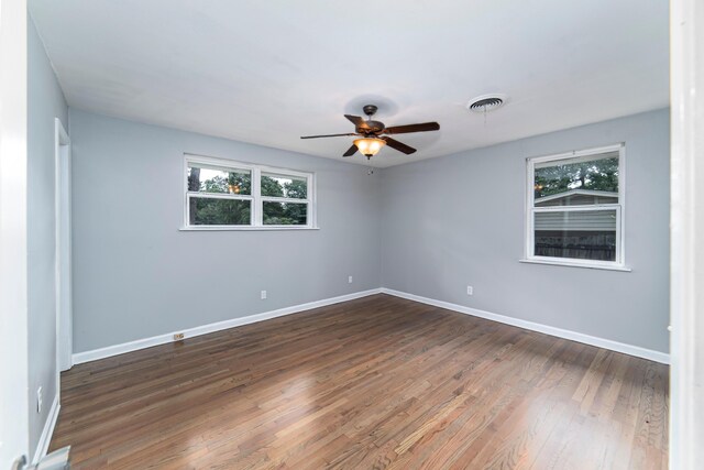 unfurnished room with ceiling fan and dark hardwood / wood-style flooring