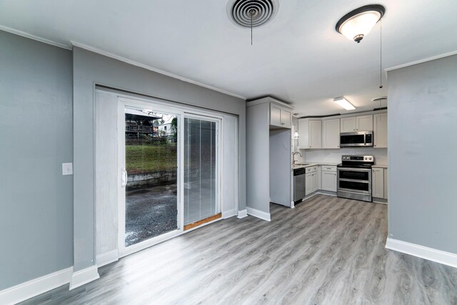 kitchen featuring sink, gray cabinets, light wood-type flooring, ornamental molding, and stainless steel appliances