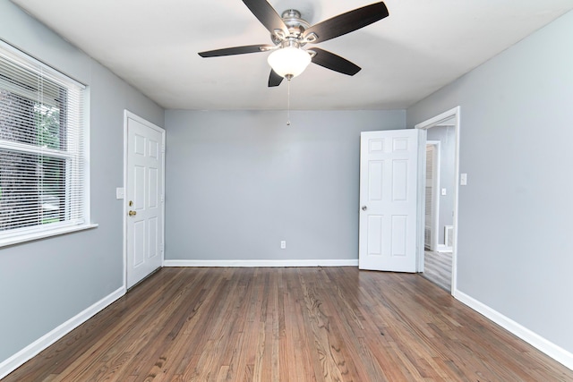 empty room with dark hardwood / wood-style floors and ceiling fan