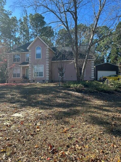 view of home's exterior with a lawn, a garage, and an outbuilding