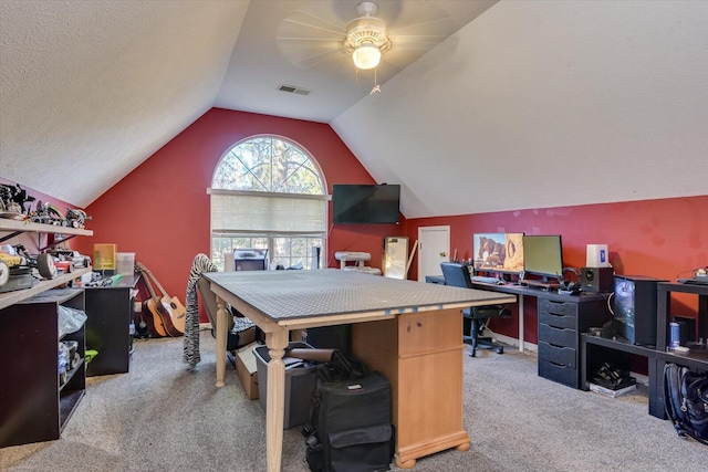 home office with a textured ceiling, ceiling fan, carpet, and vaulted ceiling